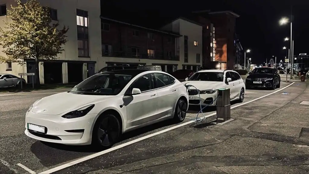 Electric cars charging at an Urban Fox chargepoint on a street at night